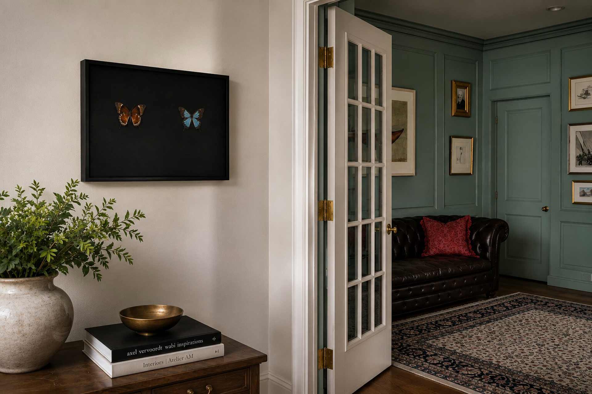 wall art featuring butterflies hanging in a living room with french doors.